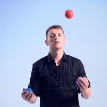 man juggling three balls